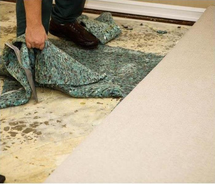 man pulling green carpet pad